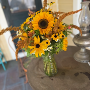 vase arrangement of sunflowers, rudbeckia, and amaranth